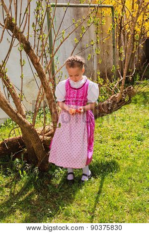 Girl in the dirndl is bored with coloured ones wobble in the hand