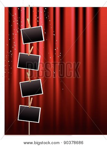 Blank photo frames hanging from a clothes line on a red curtain