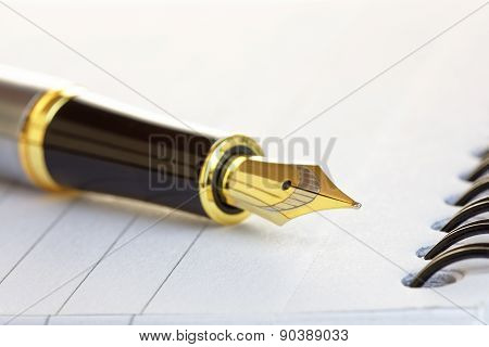 Close Up Of A Gold Fountain Pen Nib On A Notepad