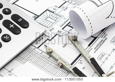 Architectural drawings of a house with compass and calculator