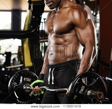 Strong bodybuilder with six pack, perfect abs, shoulders, biceps, triceps and chest
