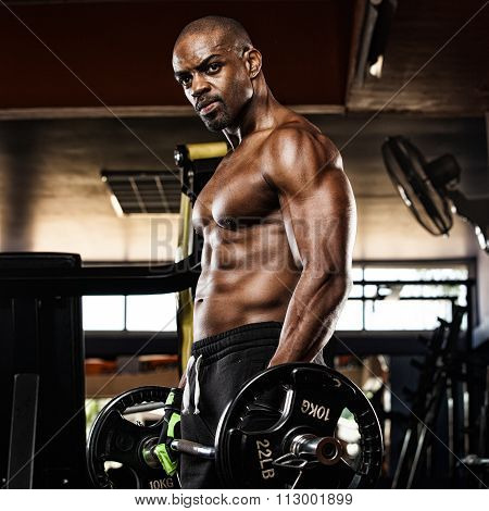 Strong bodybuilder with six pack, perfect abs, shoulders, biceps, triceps and chest