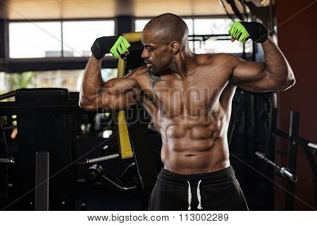 Strong bodybuilder with six pack, perfect abs, shoulders, biceps, triceps and chest