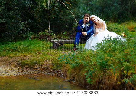 bride and groom fishing together - romantic wedding concept.