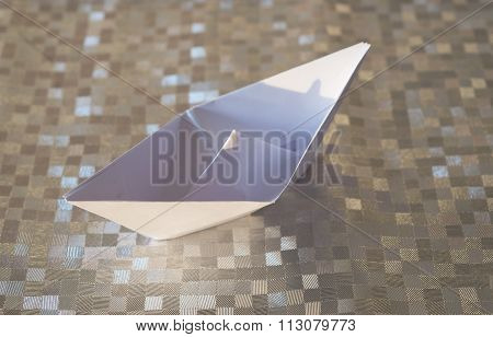 Folded White Paper Ship On A Silver Background