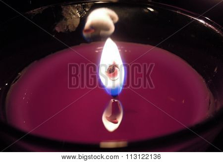 Burning candle in a glass