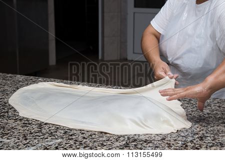 Close Up Of Female Hands Kneading Dough And Making Banitsa