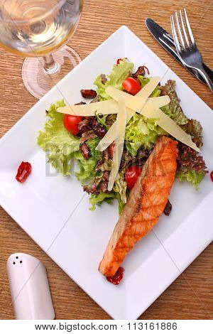 Grilled Salmon With Cheese And Vegetable Salad On White Plate