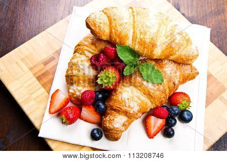 Fresh Tasty Croissants With Berries On Wooden Background
