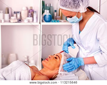 Woman middle-aged in spa salon with beautician. Female giving botox injections.