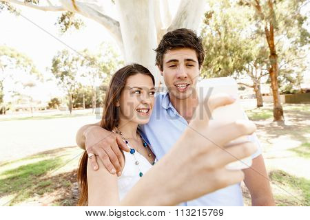 Young couple in the park making their selfi with mobile phone