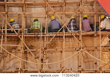 Builders restoring ancient temple