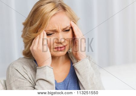 unhappy woman suffering from headache at home