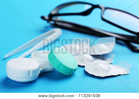 Contact Lenses In Container With Solution On Blue Background