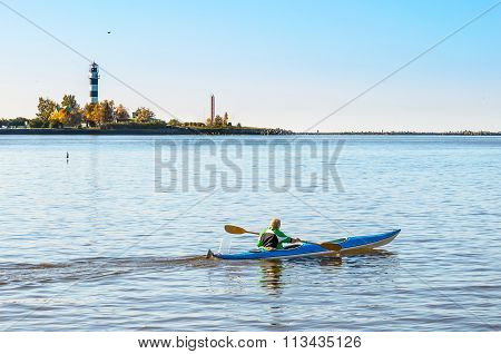 Man makes a trip by canoe on river Daugava near port of Riga