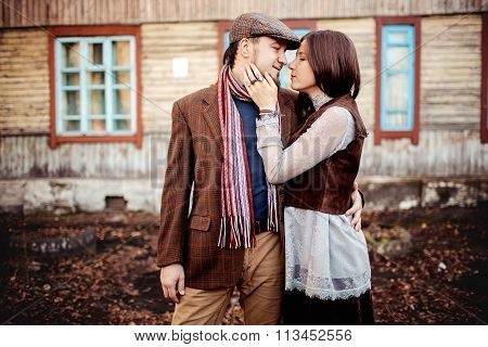 Lovely couple in stylish brown clothes looking at each other, retro style.