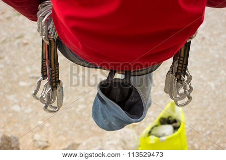 Young male climber hanging by a cliff.