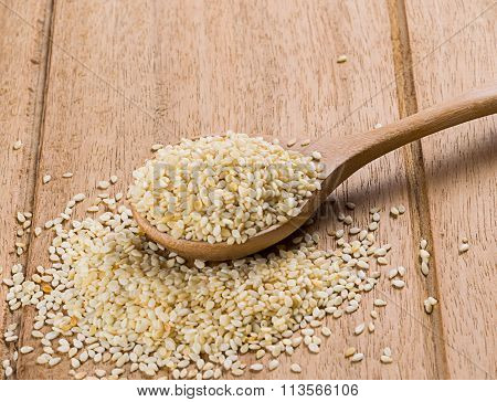 sesame seeds with wooden spoon on white background