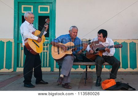 Three old man playing guitar on the street making music