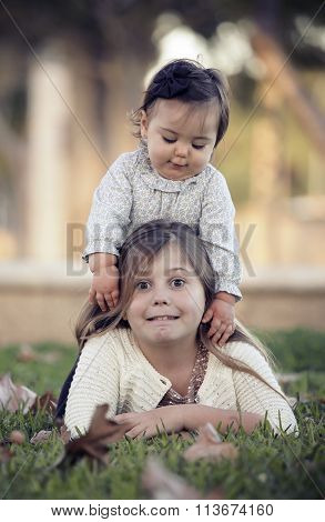 two sisters sitting in a garden in the fal