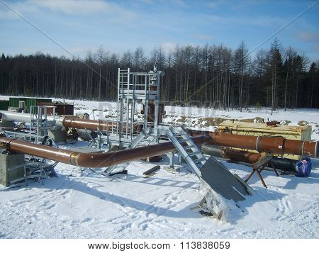 Platform of construction of pipelines. Booster pump station. Snow-covered area of the pipeline.