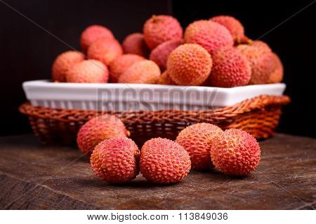Lychee Fruit, Which Is Called Chinese Plum, Is On The Dark Board And In Basket.