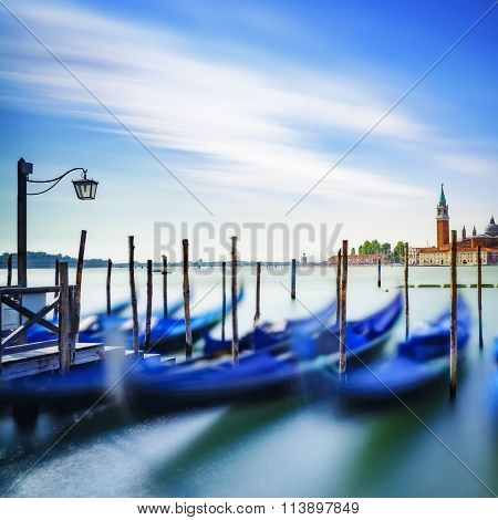 Venice, Gondolas Or Gondole On Sunset And Church On Background. Italy
