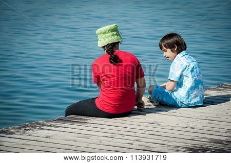Girld and boy on lake dock in Italy