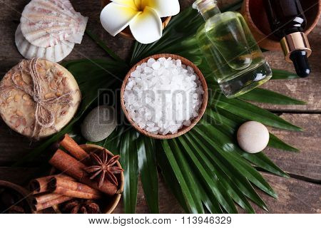 Beautiful spa setting on palm leaf on wooden table