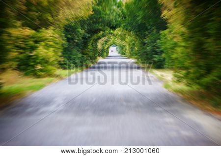 Tunnel vision:Road in motion speed on the asphalt forest road blur background.