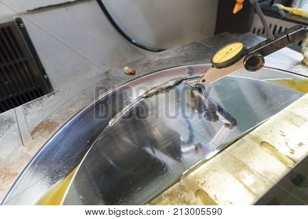 The dial gauge alignment the injection mold for CNC machining process after repair by welding method. The repair injection mold process.