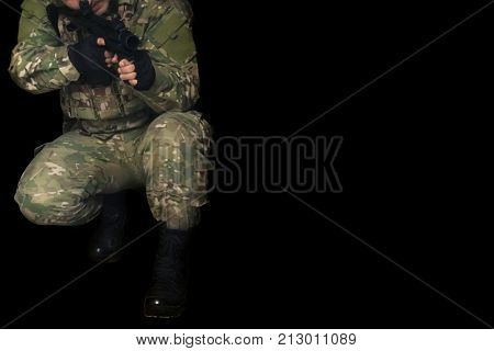 soldier in camouflage with a gun on a black background