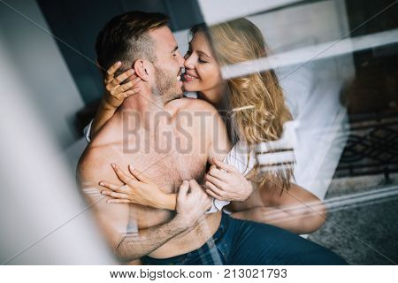 Attractive young couple sharing intimate moments in bedroom