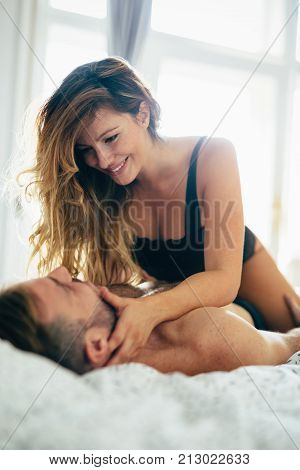 Attractive young couple sharing intimate moments in bedroom