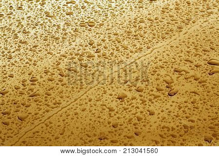 Rain Drops On Orange Color Metal Car Surface.