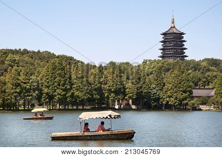HANGZHOU, CHINA - JULY 29, 2012 - Leifeng Pagoda and tourist boats, West Lake, Hangzhou