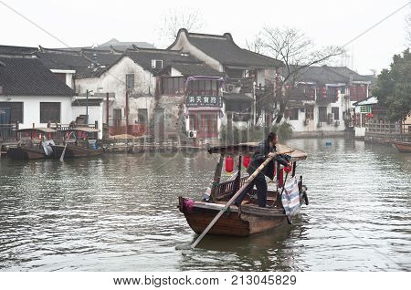 SHANGHAI, CHINA - DEC 28, 2012 - Local man rowing along a canal in Zhujiajiao water town, Shanghai, China