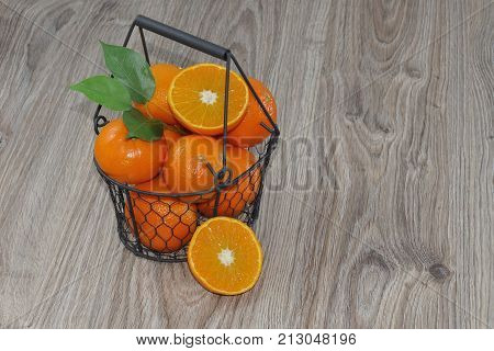 Clementines in a basket on a wooden table