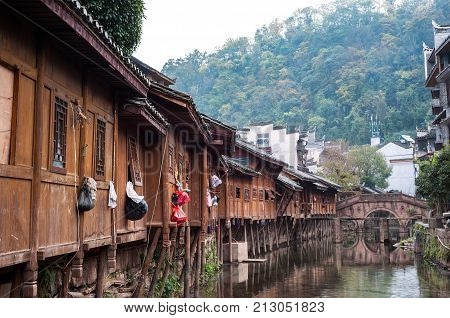 FENGHUNG, CHINA - NOV 12, 2014 - Traditional wooden buildings and ancient stone bridge in Fenghuang Ancient Town, Hunan Province, China