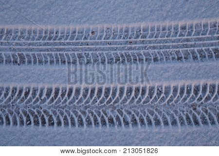 Traces from car tires on snow from two different types of tires