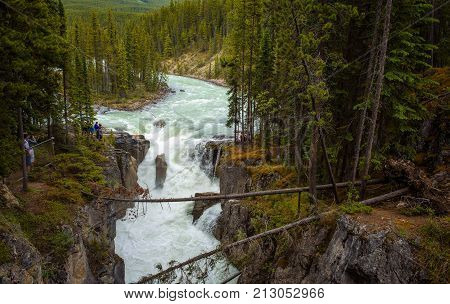 JASPER NATIONAL PARK, CANADA - JUNE 30, 2017 : Tourists enjoying view of the Upper Sunwapta Falls in Jasper National Park. The water originates from the Athabasca Glacier.