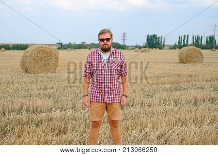 man resting after hay harvesting in haystacks