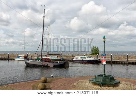 URK, THE NETHERLANDS - JUNE 18, 2016: Harbor of Dutch city Urk with historic wooden fishing ship sailing to the sea.