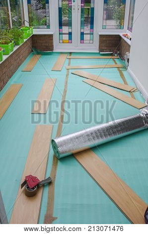 Laying laminate flooring. Insulated underlay on floor ready for the click lock wood effect laminate flooring to be laid. DIY project in a domestic home conservatory.