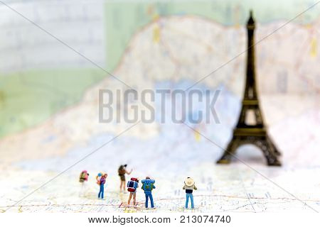 Miniature Group hiker and traveler backpack standing on wold map for travel Eiffel Tower in France and around the world select focus Travel Concept