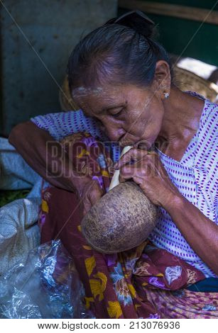 BAGAN MYANMAR- SEP 04 : Woman smoking a cheroot cigar in market in bagan Myanmar on September 04 2017. Cheroot is a cigar made by dried fruits and little bit of tobacco