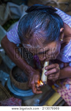 BAGAN MYANMAR- SEP 04 : Woman smoking a cheroot cigar in market in bagan Myanmar on September 04 2017. Cheroot is a cigar made by dried fruits and little bit of tobacco