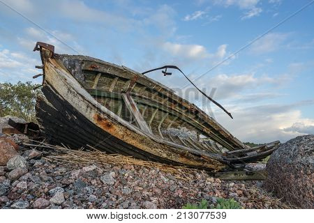 Old boat shore evening light sunset clouds and architecture concept in the Baltic Sea. Mohni small island in Estonia Europe.