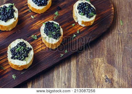 Appetizer for christmas table - black caviar on the pieces of bread