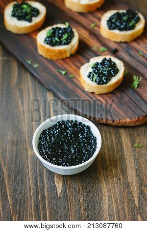 Fresh black caviar in a white ceramic bowl